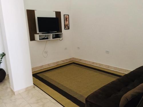 a living room with a couch and a flat screen tv at Hospedagem Alto da Montanha in Cunha