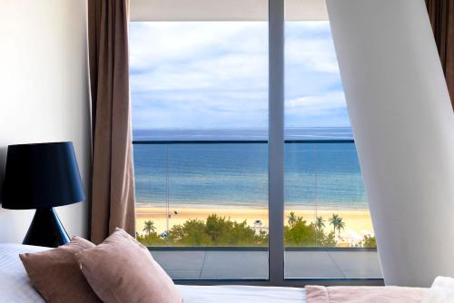 sypialnia z widokiem na plażę i ocean w obiekcie WAVE private apartment - Fancy Sunset w mieście Międzyzdroje