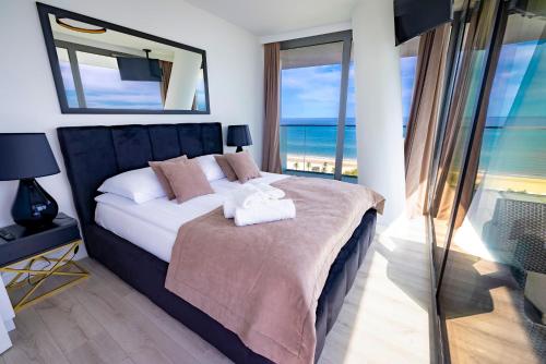a bedroom with a bed with a view of the ocean at WAVE private apartment - Fancy Sunset in Międzyzdroje