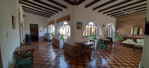 聖馬科斯塞拉利昂的住宿－Jaracanda Hostel San Marcos，客厅设有两扇窗户和砖墙