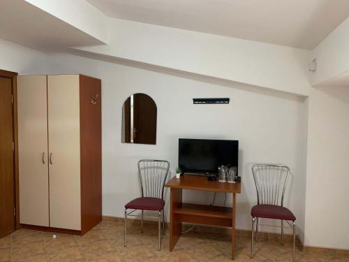 a room with a table and two chairs and a television at Royal L Hotel in Carev Dvor