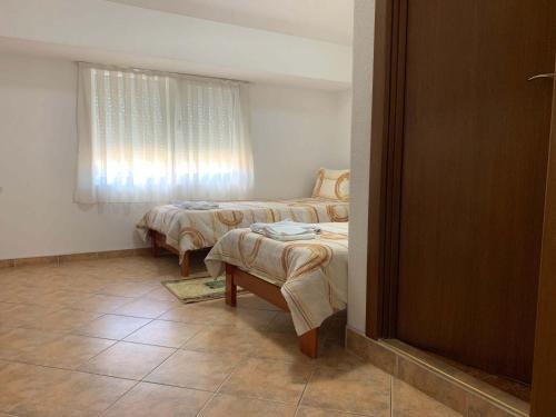 a room with two beds and a table and a window at Royal L Hotel in Carev Dvor