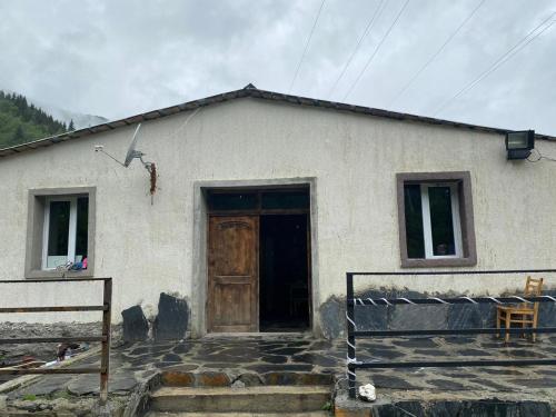 ein kleines weißes Haus mit einer Holztür in der Unterkunft Hotel Dauber in Lalkhori