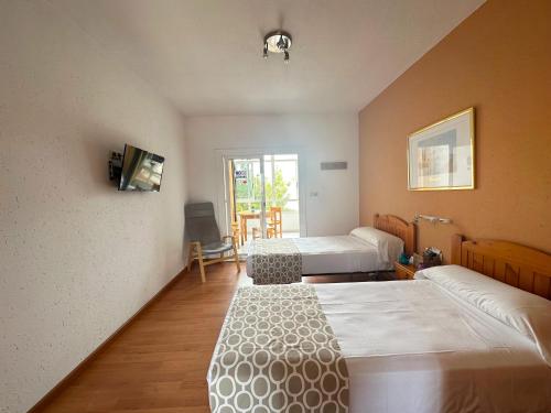 Habitación de hotel con 2 camas y TV en Apartamentos Sol y Luna 3000, en Peñíscola