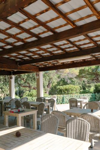 d'une terrasse avec des tables et des chaises et un plafond en bois. dans l'établissement Camping Ladouceur, à Ramatuelle
