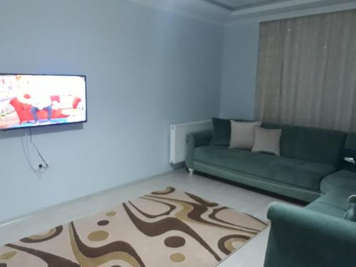 a living room with a couch and a flat screen tv at günlük aylık kralık daire in Arsin