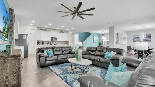 a living room with leather couches and a kitchen at 1840 Caribbean View in Kissimmee