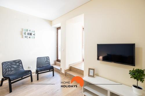 un soggiorno con 2 sedie e una TV a parete di #073 Private Terrace, 2min Beach with AC ad Albufeira