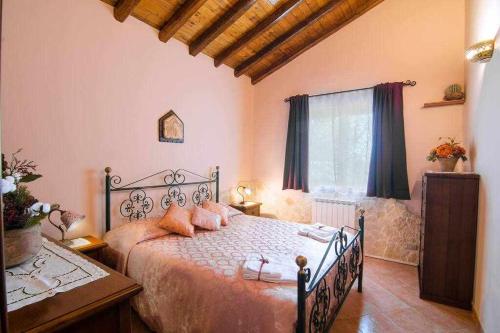 マスカリにあるVilla del Gelso Chalet nel Parco dellEtnaのベッドルーム1室(大型ベッド1台、枕付)