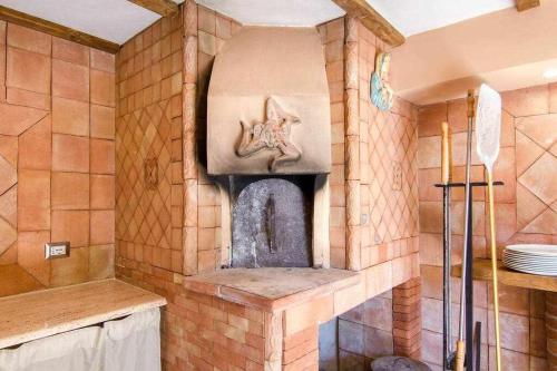 a kitchen with a stone fireplace in a room at Villa del Gelso Chalet nel Parco dellEtna in Mascali