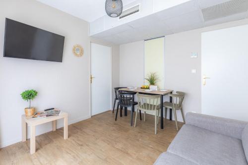 a living room with a table and a couch at Appart'City Classic Bordeaux Centre in Bordeaux
