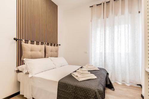 a bedroom with a bed with white sheets and a window at Casa Roma B&B in Rome