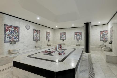 Un baño con tres lavabos y una mesa en una habitación. en Kaya Side, en Side