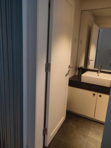 La salle de bains est pourvue d'un lavabo et d'une porte blanche. dans l'établissement 理想方向, à Lisbonne