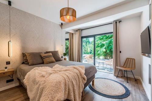 une chambre avec un lit et une porte coulissante en verre dans l'établissement Villa Quartier Oxford garden & pool in Cannes AC, à Cannes