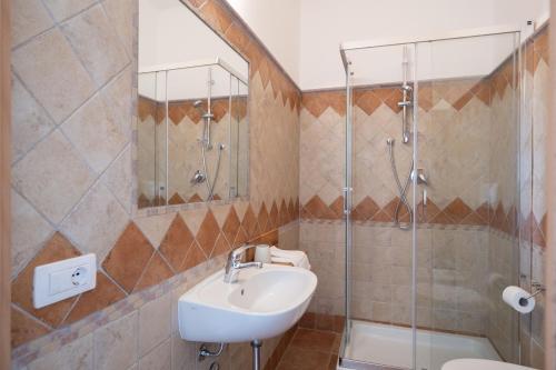 a bathroom with a sink and a shower at Nautika Suites in Alghero