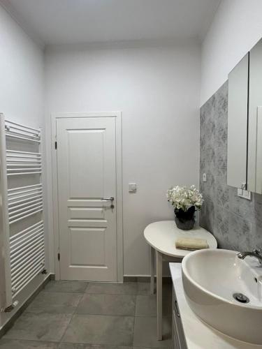 a white bathroom with a sink and a white door at Exclusive apartment in Supetarska Draga
