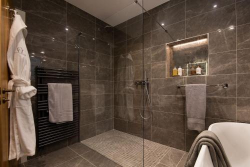 uma casa de banho com um chuveiro e uma porta de vidro em Roundhill Coach House 