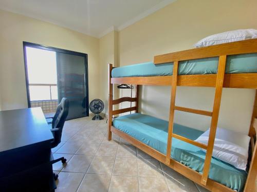 1 dormitorio con literas en una habitación con escritorio en A201 - Vista Mar | 3 Quartos c/ Wifi e Churrasqueira, en Samaritá