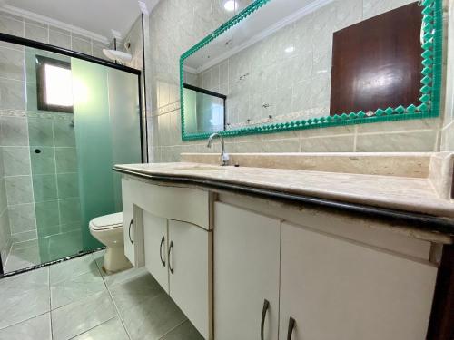 Un baño con lavabo, inodoro y espejo. en A201 - Vista Mar | 3 Quartos c/ Wifi e Churrasqueira, en Samaritá