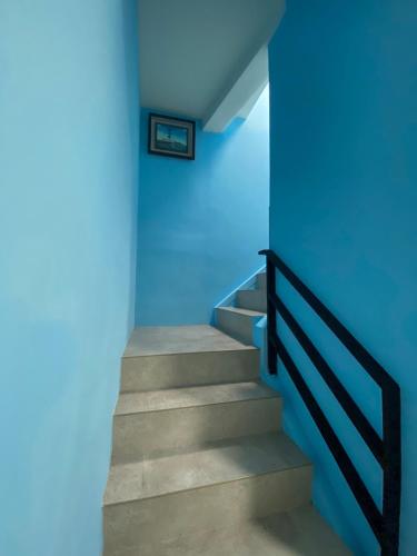 a staircase in a blue room with a blue wall at 亞士密民宿 in Puli