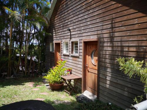 a building with a bench next to a door at Les bungalows de la kazouale in Saint-Leu