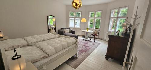 Kleines Landhaus am Wald Bad Saarow في باد سارو: غرفة نوم مع سرير وغرفة معيشة