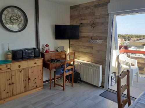 une pièce avec un bureau et une télévision sur un mur dans l'établissement Studio Cabine Sainte-Cécile à 100m de la plage, à Camiers