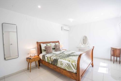 - une chambre blanche avec un lit et un miroir dans l'établissement Villa Luxe, à Calp