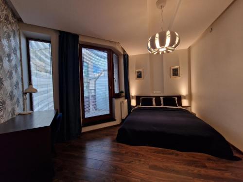 a bedroom with a bed and a large window at Happy Apartments - Old Town in Wrocław