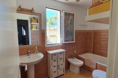 uma casa de banho com um lavatório, uma banheira e um WC. em Acogedor chalet adosado en playas de Isla Cristina em La Redondela