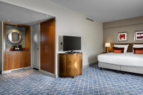 a bedroom with a bed and a flat screen tv at Warwick Grand-Place Brussels in Brussels