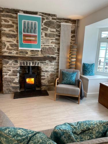a living room with a stone fireplace and a chair at Number Eleven, Brixham in Brixham