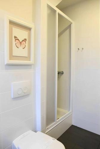 a bathroom with a toilet and a picture of a butterfly at Sleephotels in Hamburg