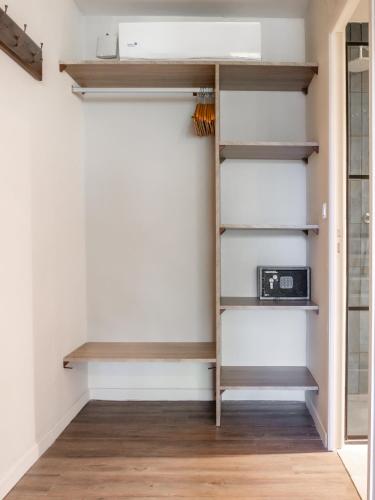 a closet with wooden shelves and a toaster at Hôtel Iloma in Sainte-Luce