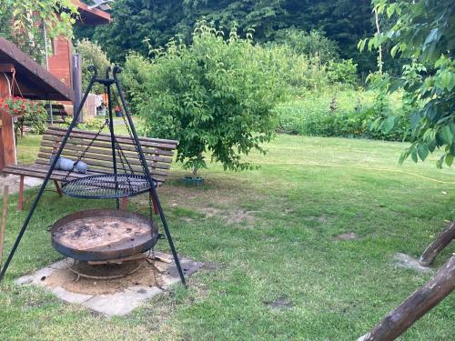 a grill in a yard next to a bench at Pod Dębem in Białowieża