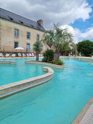 a swimming pool with blue water in front of a building at Camping de l Orangerie de Lanniron Mobilhome Esprit Zen R26 in Quimper