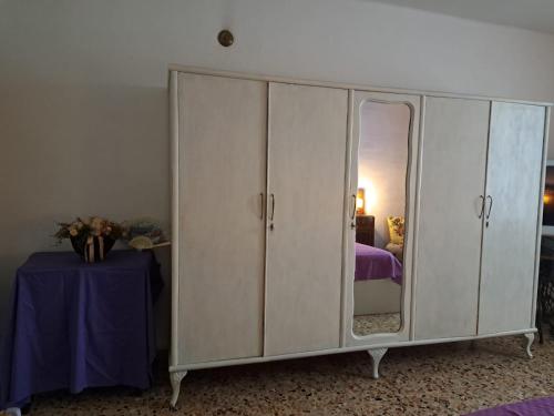 a white cabinet with a mirror in a bedroom at Casa Luci d'Alba in Monzambano