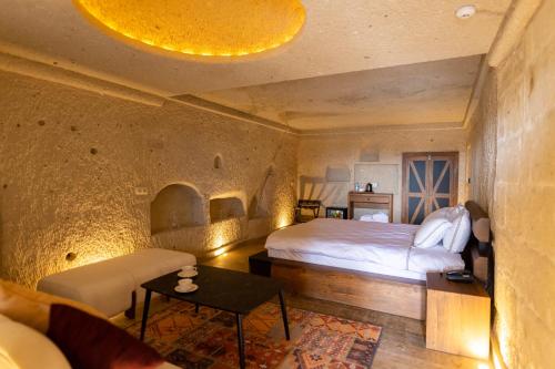 una camera da letto con un letto, un divano e un tavolo di Olenda Cappadocia Hotel a Üçhisar