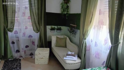 Habitación con cortinas, silla y mesa. en La Sosta in Lunigiana en Monti di Licciana Nardi