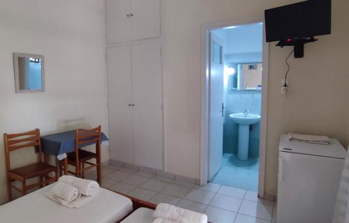 a bathroom with a table and a sink and a room at ΠΕΡΣΕΦΟΝΗ in Kamena Vourla