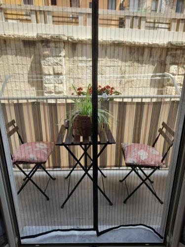 a balcony with a table and two chairs and a window at La casetta del mare in Gela