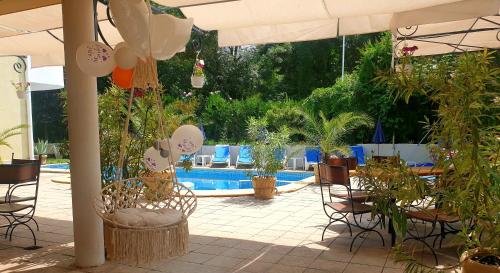 une terrasse avec des chaises, des plantes et une piscine dans l'établissement Hotel Feniks, à Lozenets