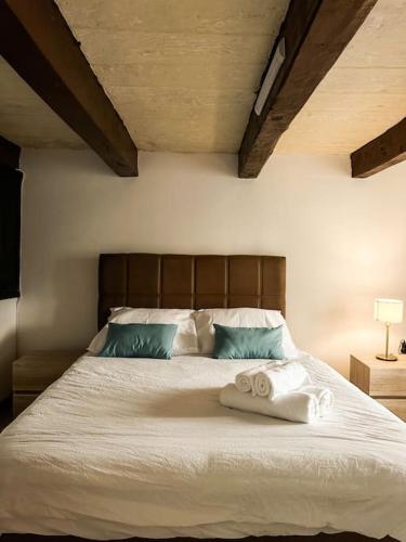 a bedroom with a bed with towels on it at Traditional Townhouse on the Main Street in Valletta Blue Door in Valletta
