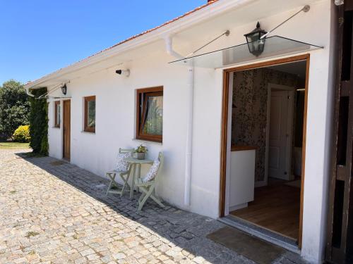 een wit huis met een patio en een tafel bij Casa dos meus avós -Villas - Gaia & Porto in Vila Nova de Gaia