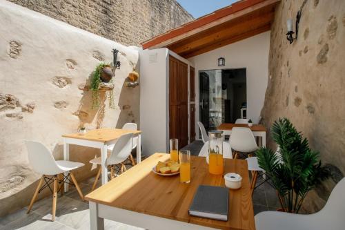 a dining room with a wooden table and white chairs at Óbidos Pátio House in Óbidos
