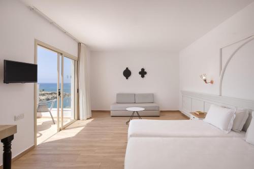 a bedroom with two beds and a view of the ocean at Atlantica Akteon in Paphos City