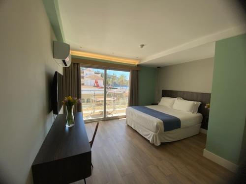H Boutique la Caleta bay في لا هيرادورا: غرفه فندقيه بسرير ونافذه