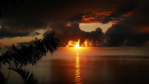 a fire explosion in the ocean at sunset at Les bungalows de la kazouale in Saint-Leu