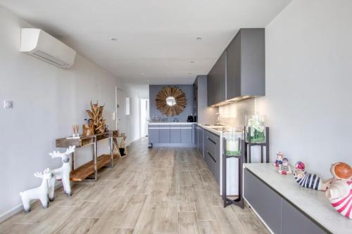 - une cuisine avec du parquet et des placards gris dans l'établissement Bright 50 m in the centre of Sanary-sur-Mer, à Sanary-sur-Mer
